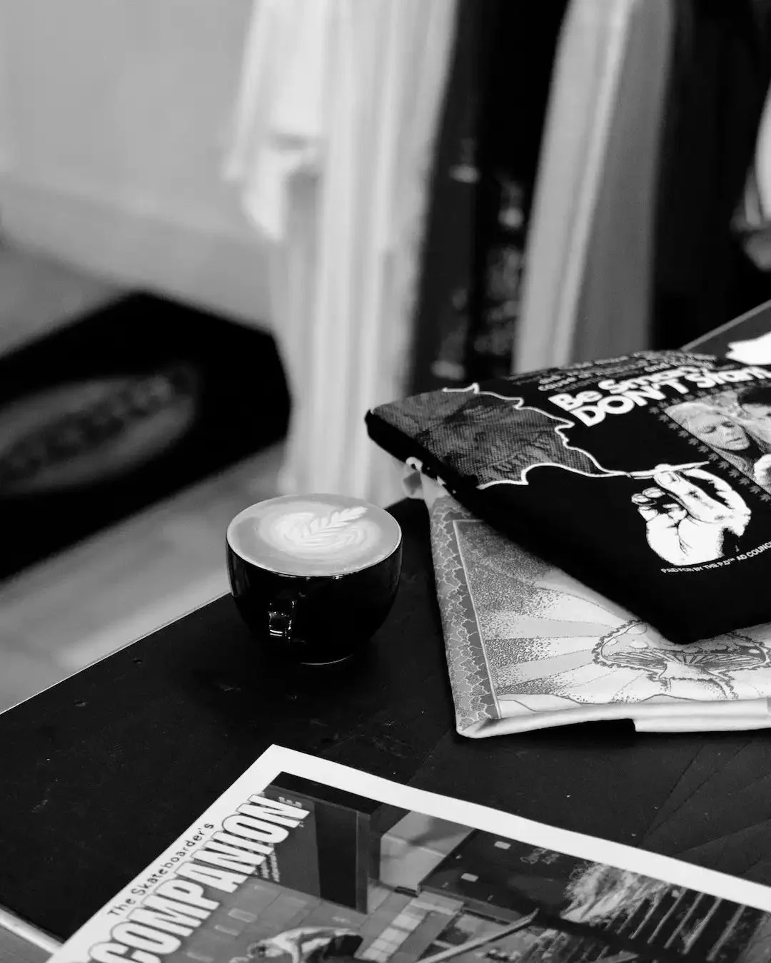 A cup of coffee beside skate magazines at Grind Supply Co