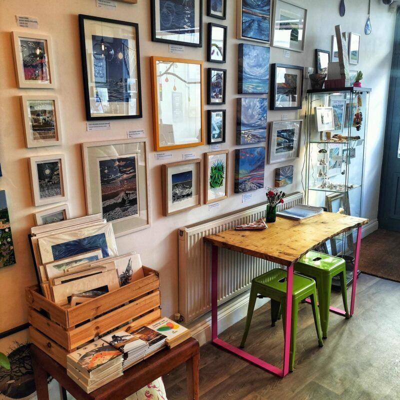 Local artwork above small colourful tables inside hand:plant