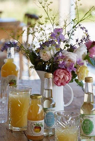 Flowers and Heron Valley juice bottles on a table