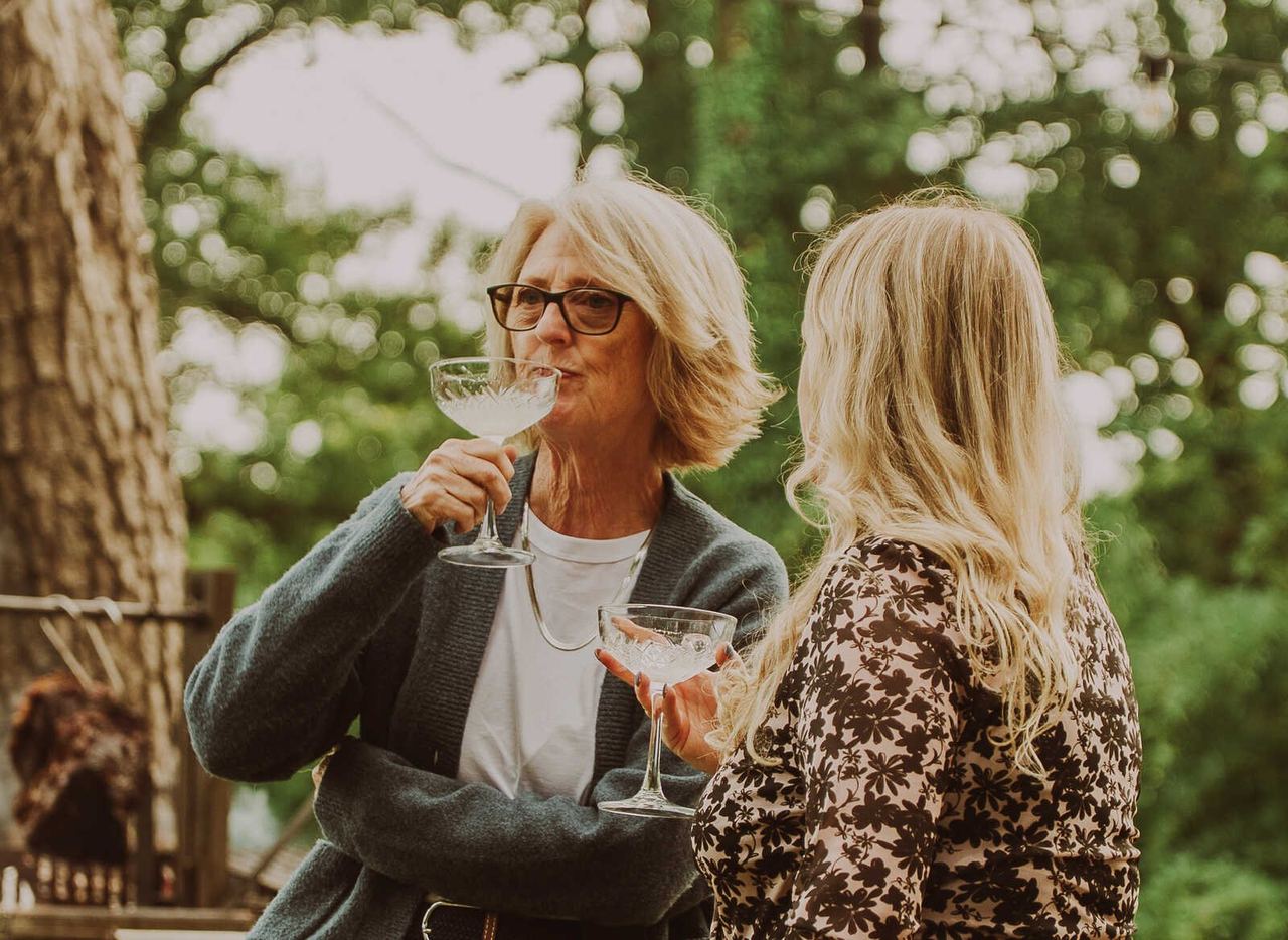Guests sharing drinks at an outdoor High Grange table