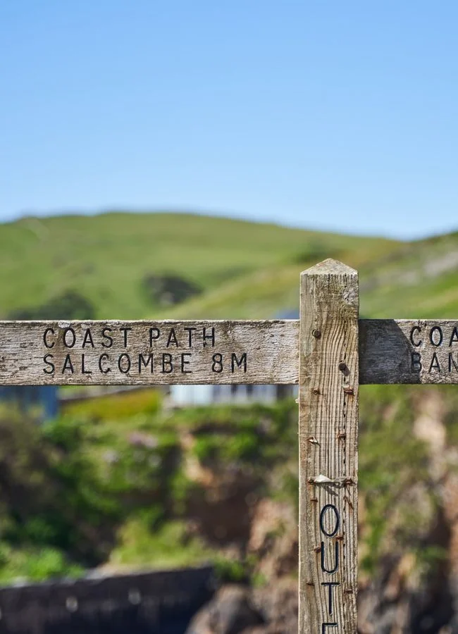 Wooden coast-path sign pointing towards Salcombe
