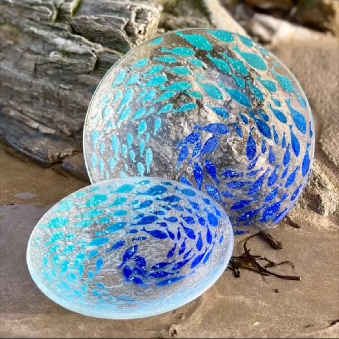 Blue and turquoise glass pieces beside coastal rock