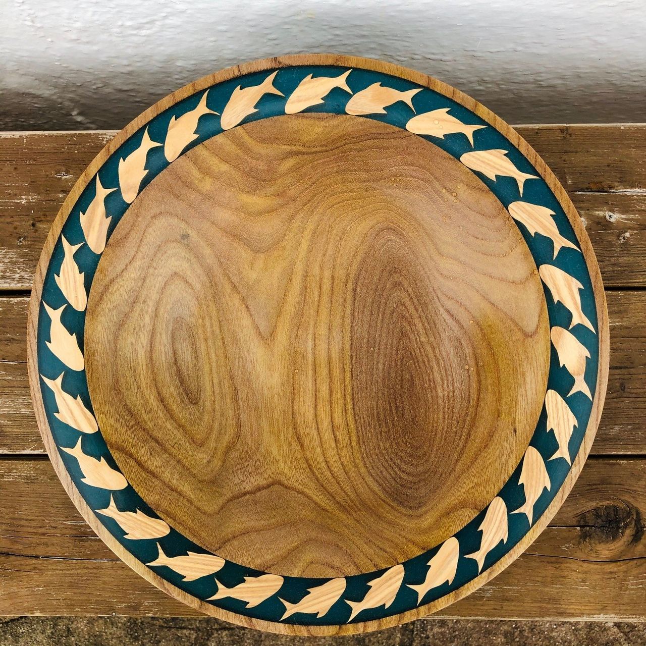 A wooden bowl with a patterned painted rim