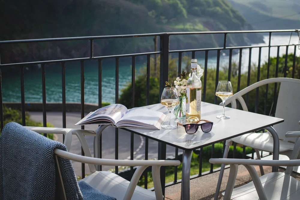 Table laid on a balcony terrace above the blue-green cove