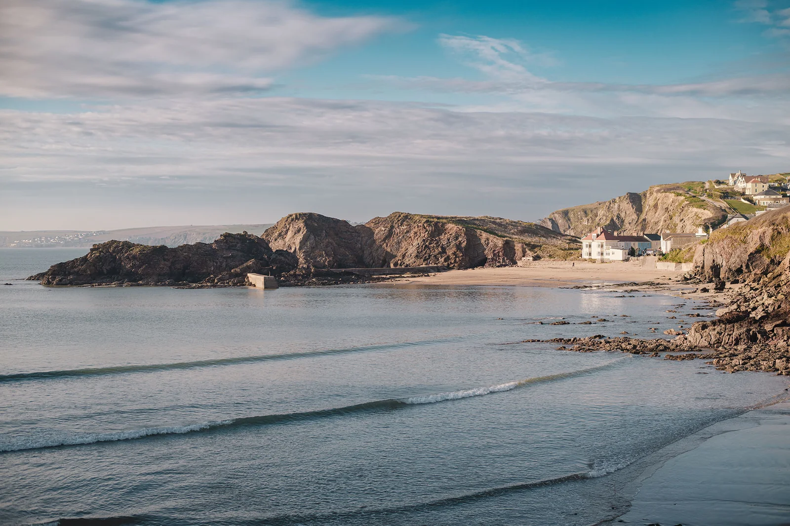 Beach and sheltered harbour at Hope Cove under a blue sky