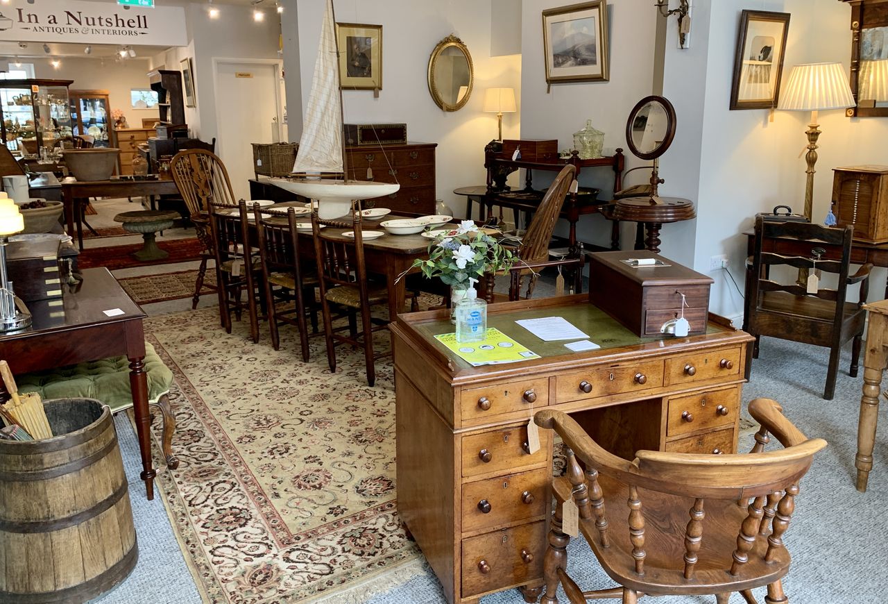 Antique wooden tables, chairs and dressers arranged inside In A Nutshell in Ashburton