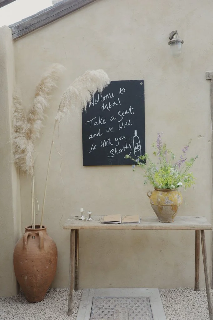 A small table, pottery and a chalkboard inside Inba