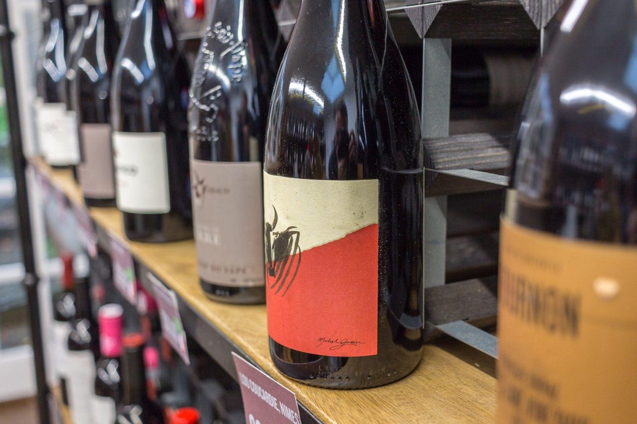 Rows of wine bottles on wooden shelves at Jaded Palates in Ashburton