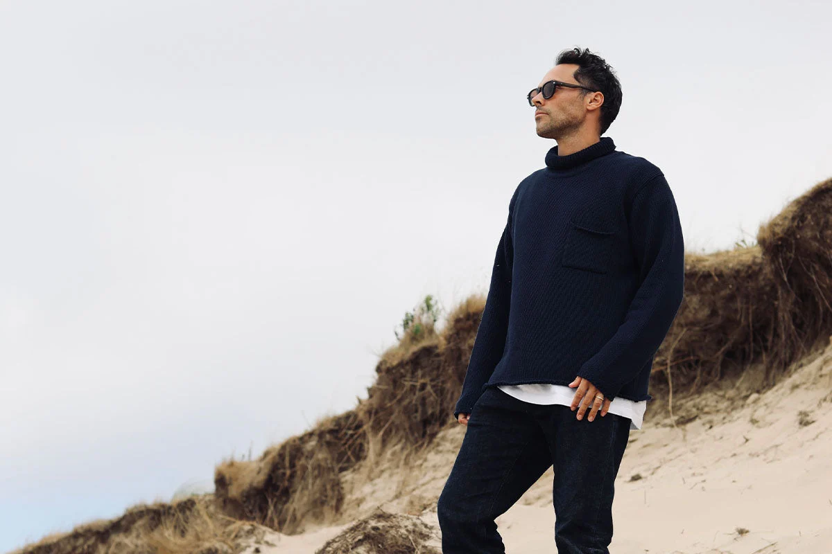 JAM Industries’ official campaign photograph of a model in a dark knitted polo by dunes