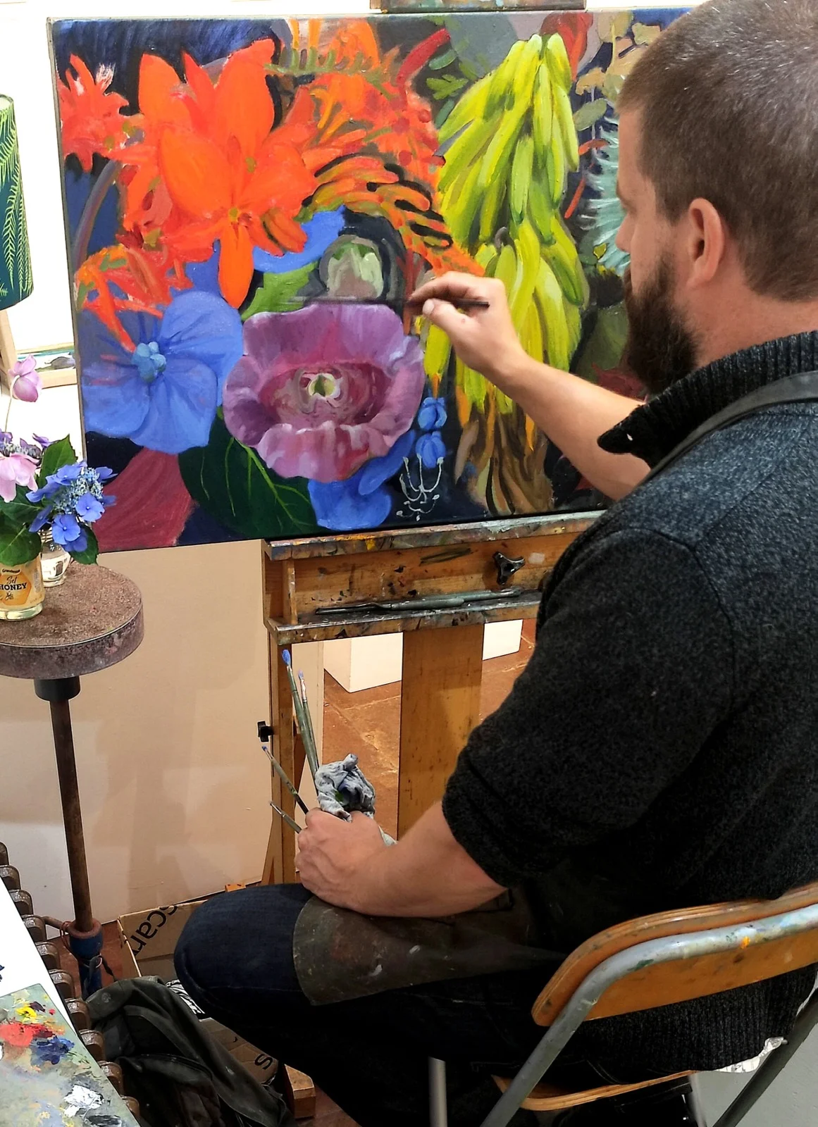 James Murch painting a large colourful floral canvas