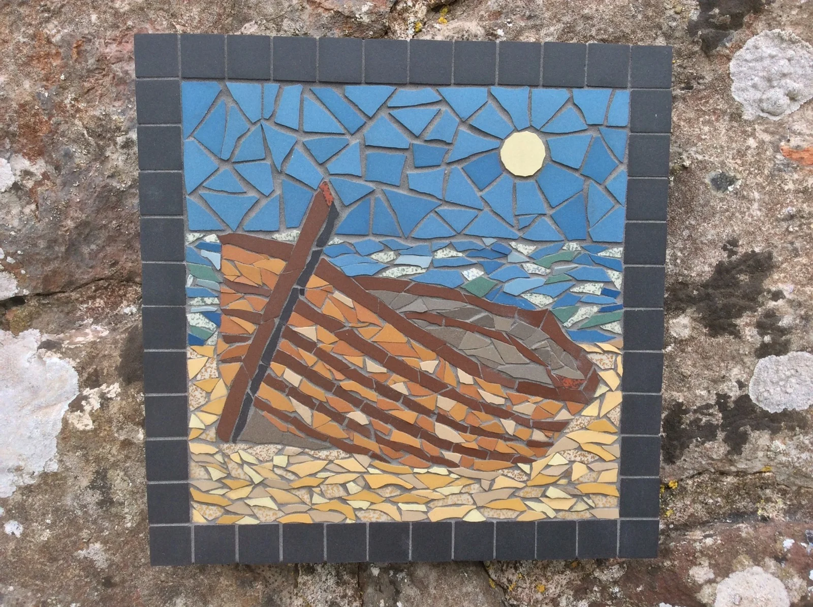 Mosaic picture of a wooden boat beneath the moon