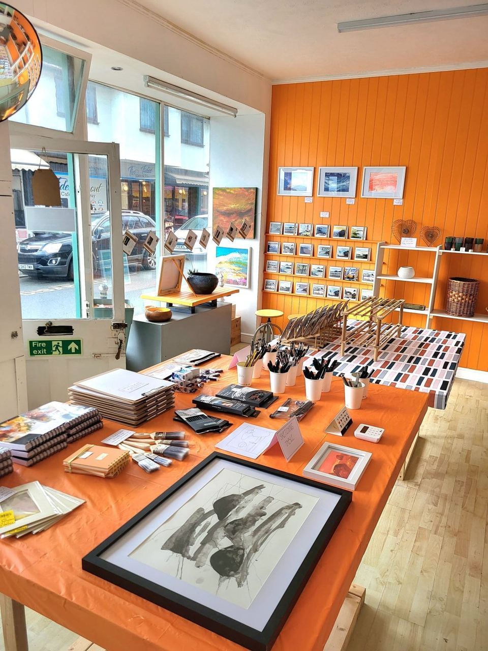 Orange walls and shelves of handmade objects inside The Lighthouse