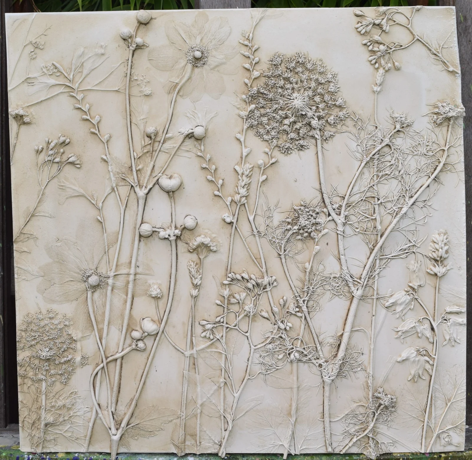 Pale botanical relief cast with raised flowers and stems