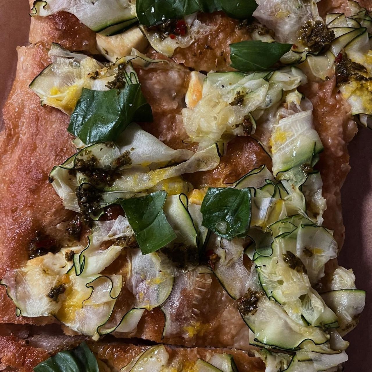 A slice of focaccia topped with vegetables at Luna’s