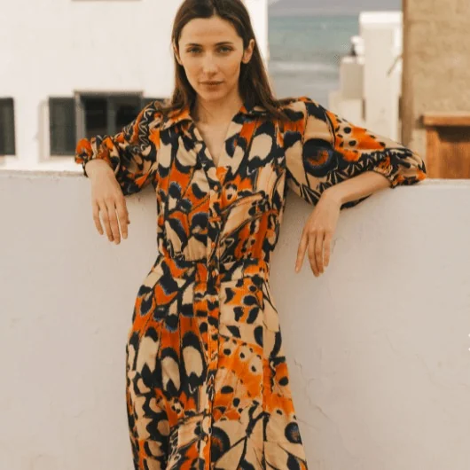 A model wearing a patterned dress stocked by Maison et Vie