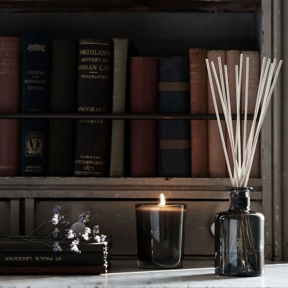 True Grace candle and diffuser beside stacked books