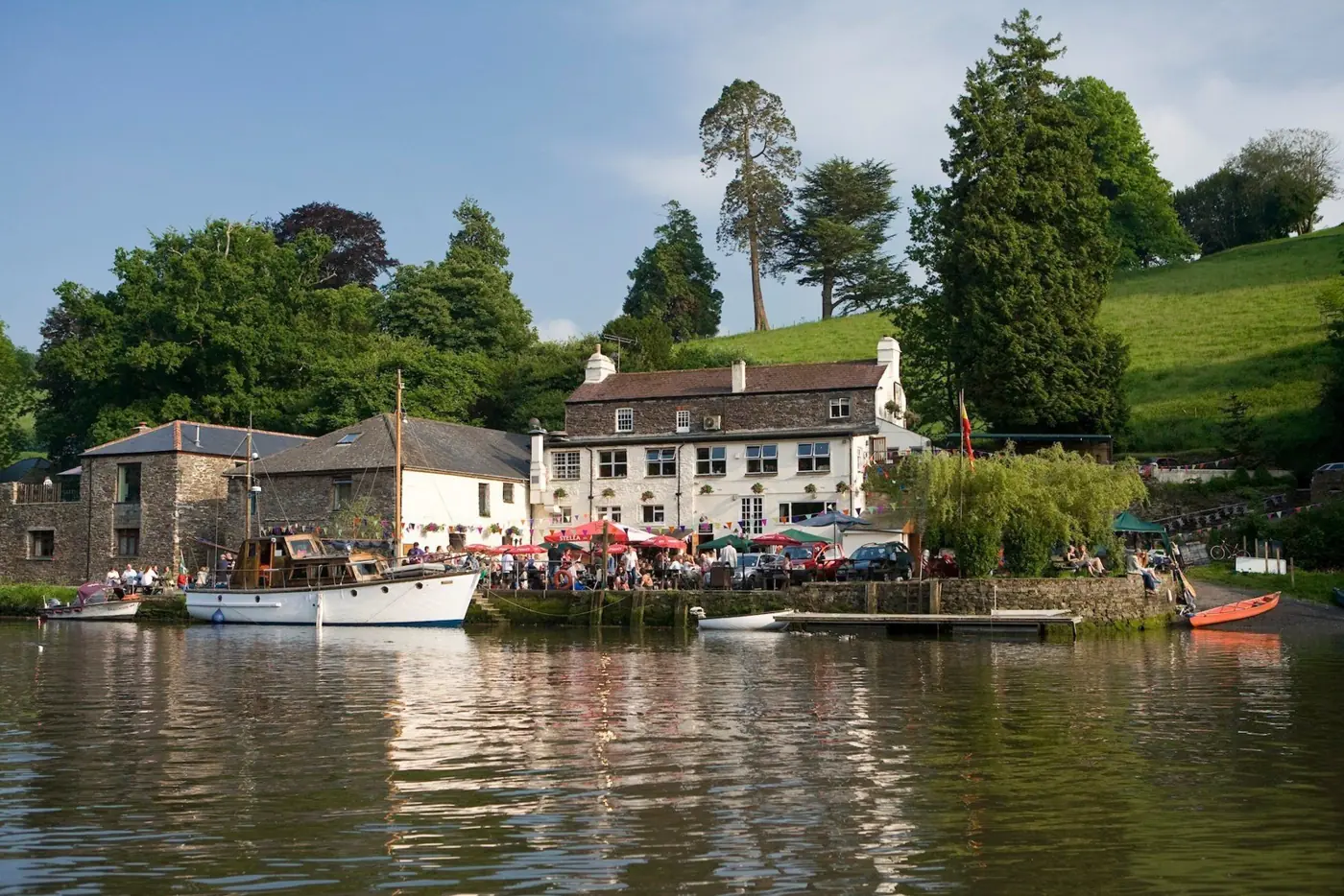 The Maltsters Arms and riverside tables seen across the water
