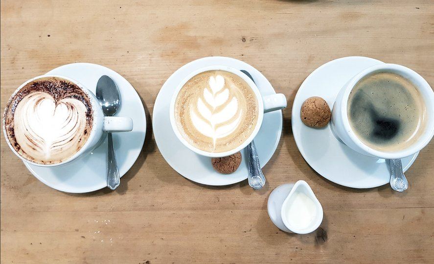 Three coffees viewed from above on a café table