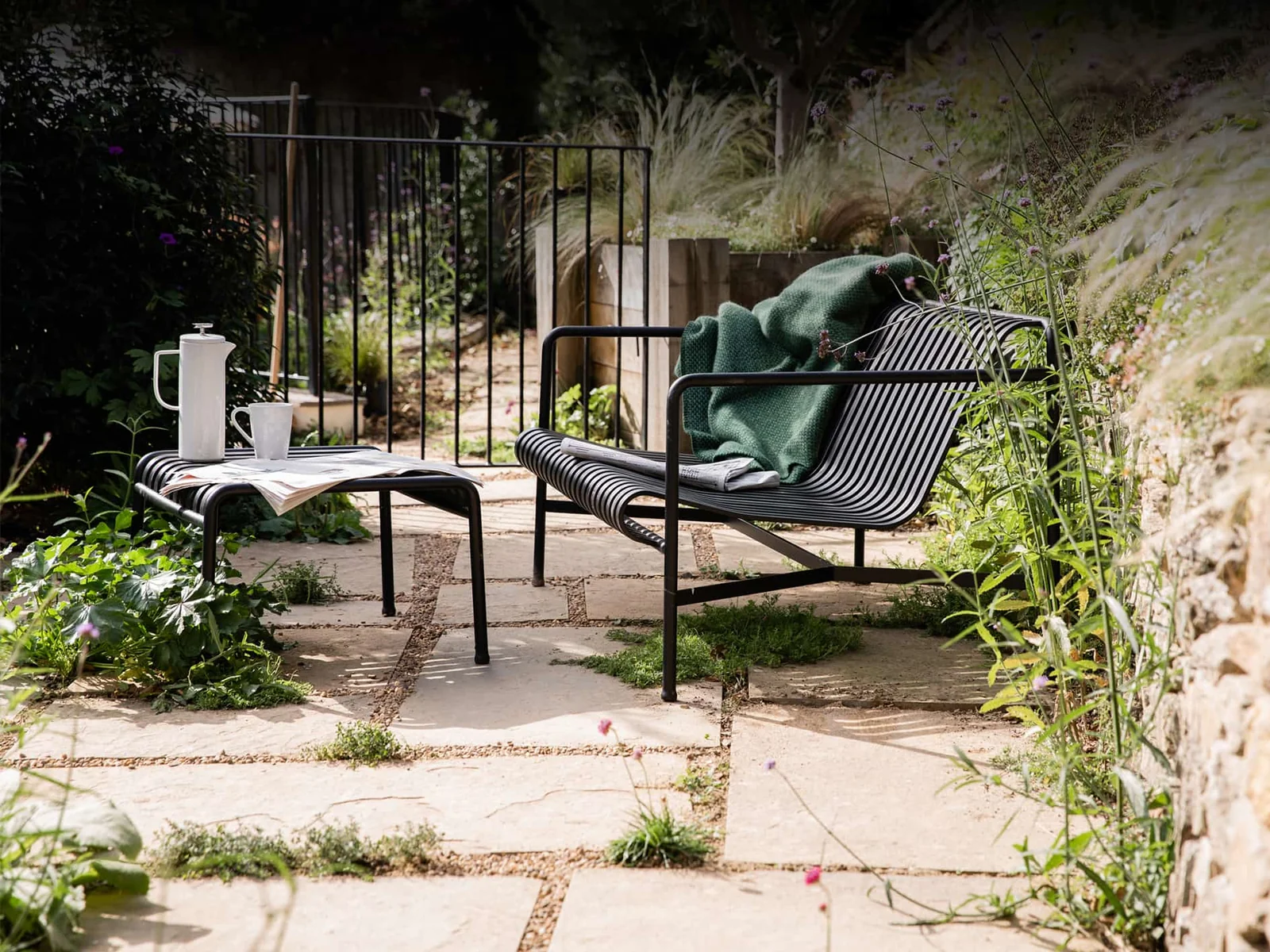Garden seating beside planting and a stone path