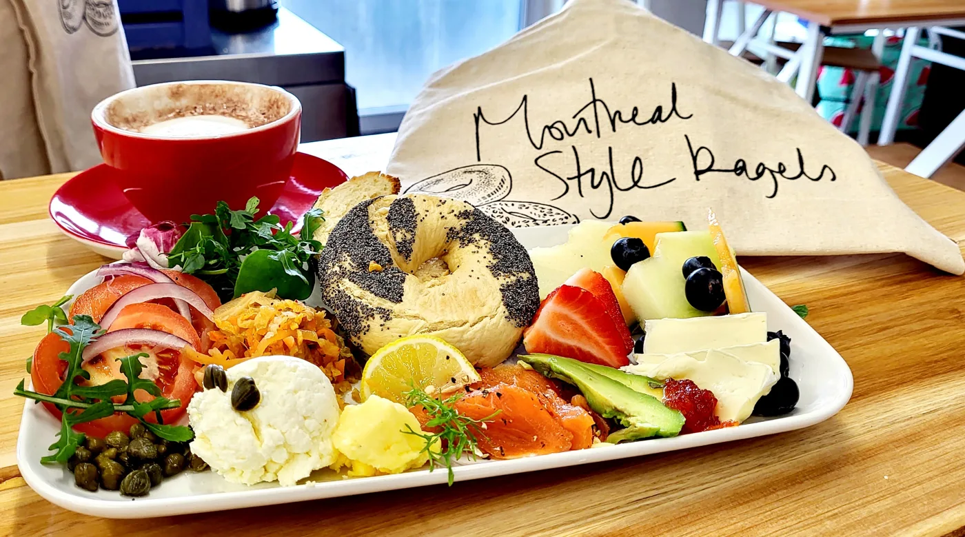 Bagel platter and a red coffee cup at Montreal Style Bagels