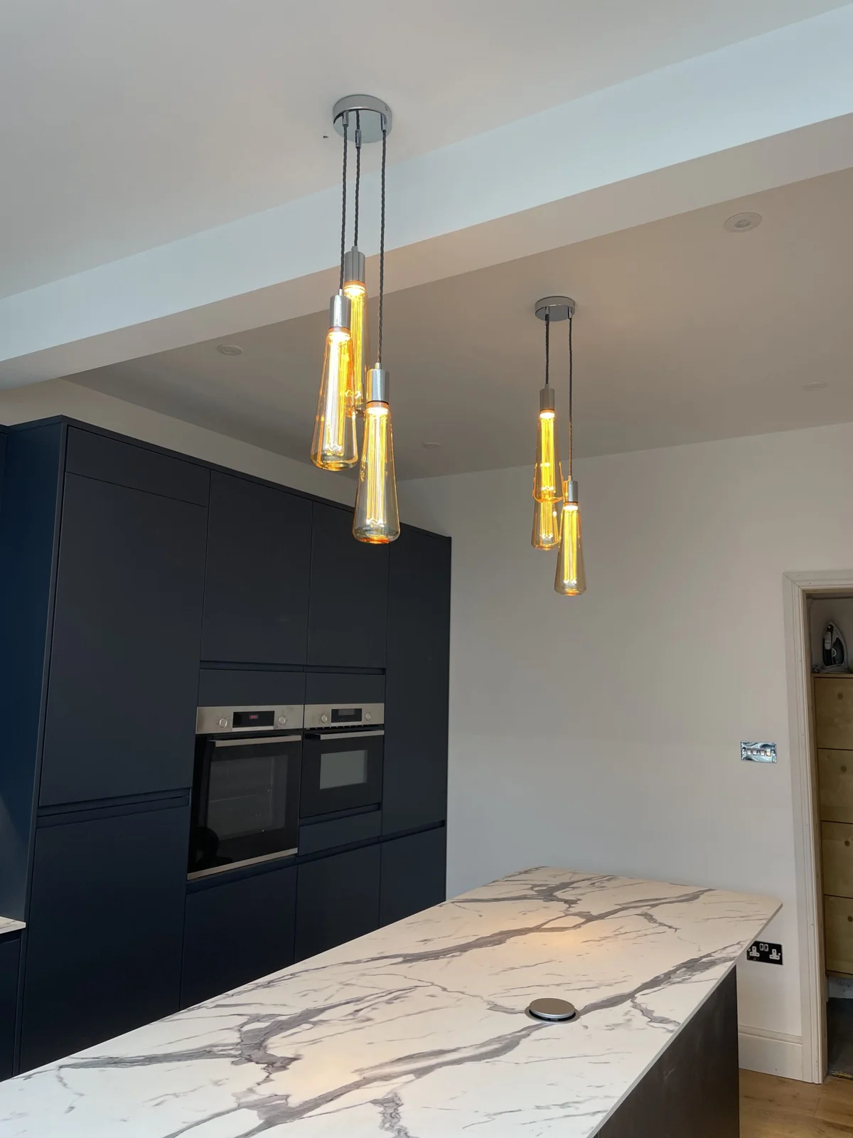 Three slim MooBoo pendant lights above a marble worktop