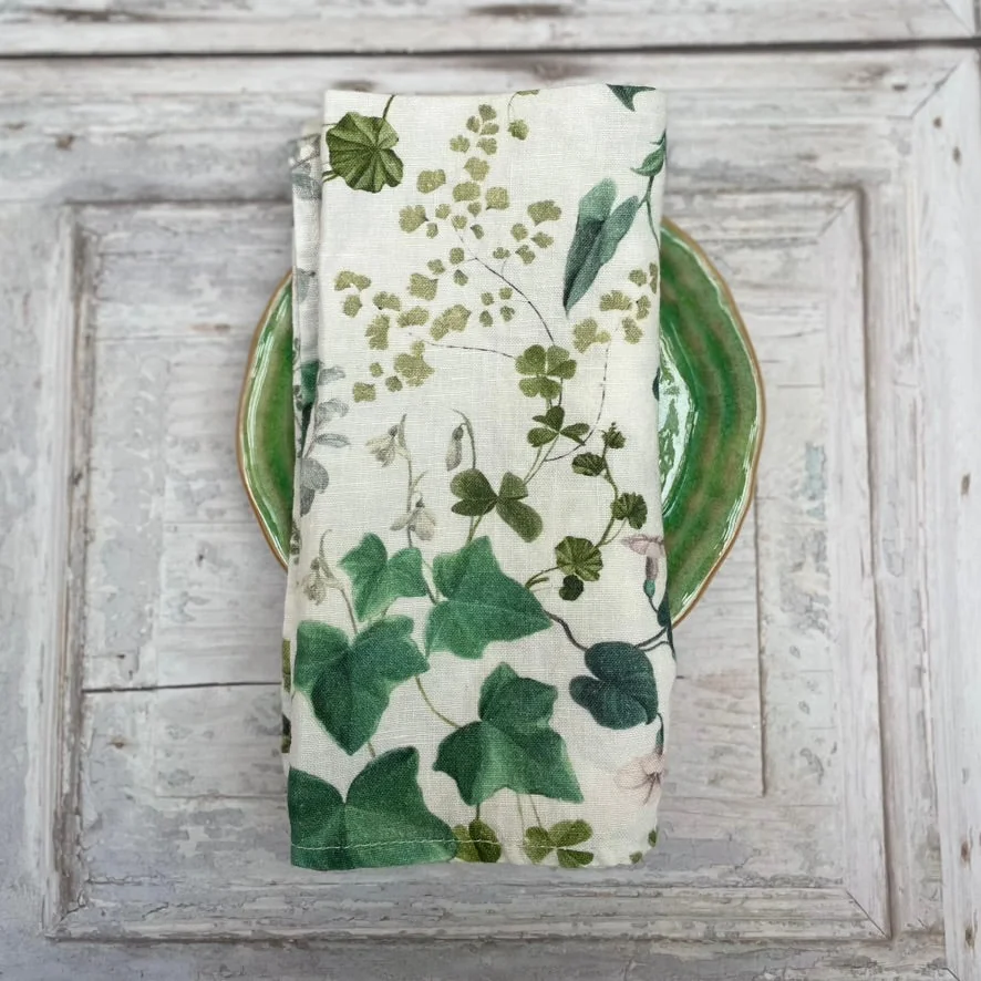 Floral printed napkin hanging against a pale panelled background