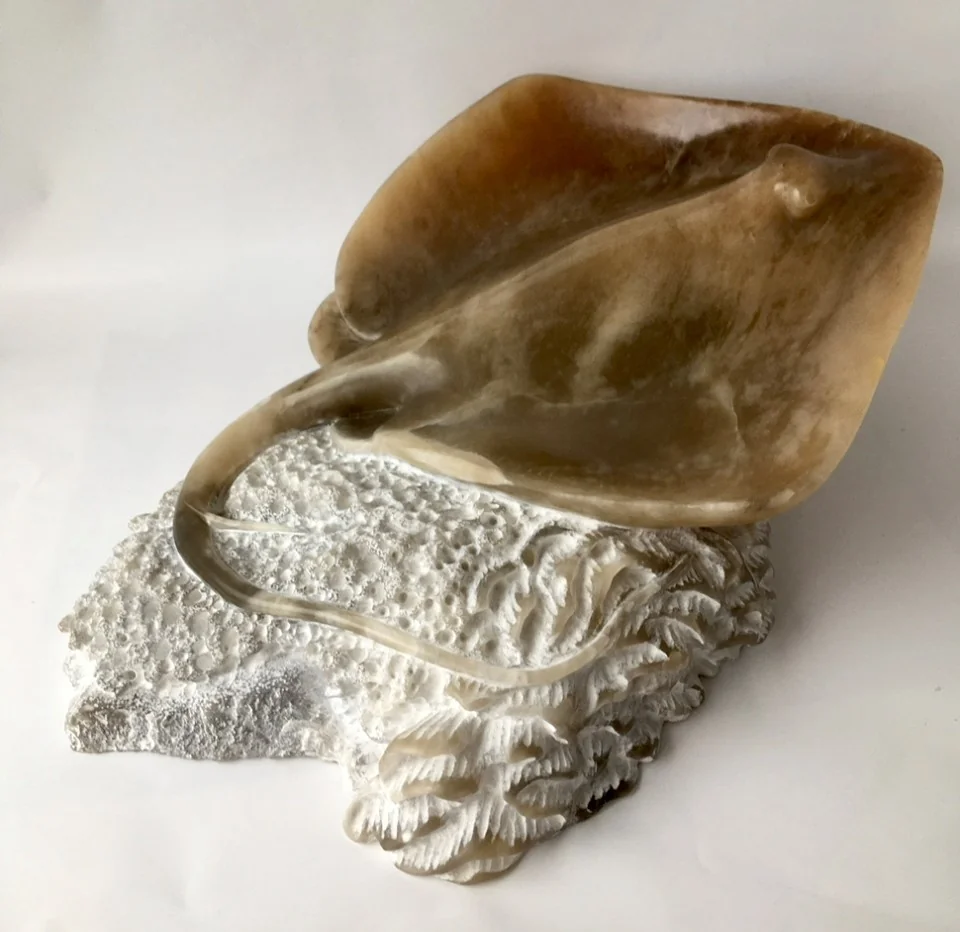 Polished brown and pale stone sculpture of a ray