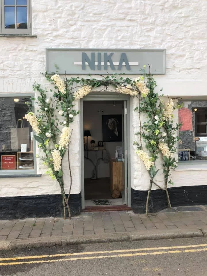 NIKA’s whitewashed Salcombe shop entrance framed with flowers