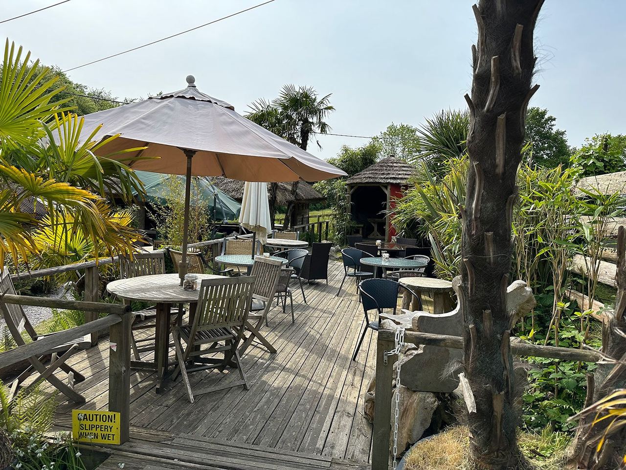 Decked outdoor seating with parasols and plants at Oak Barn