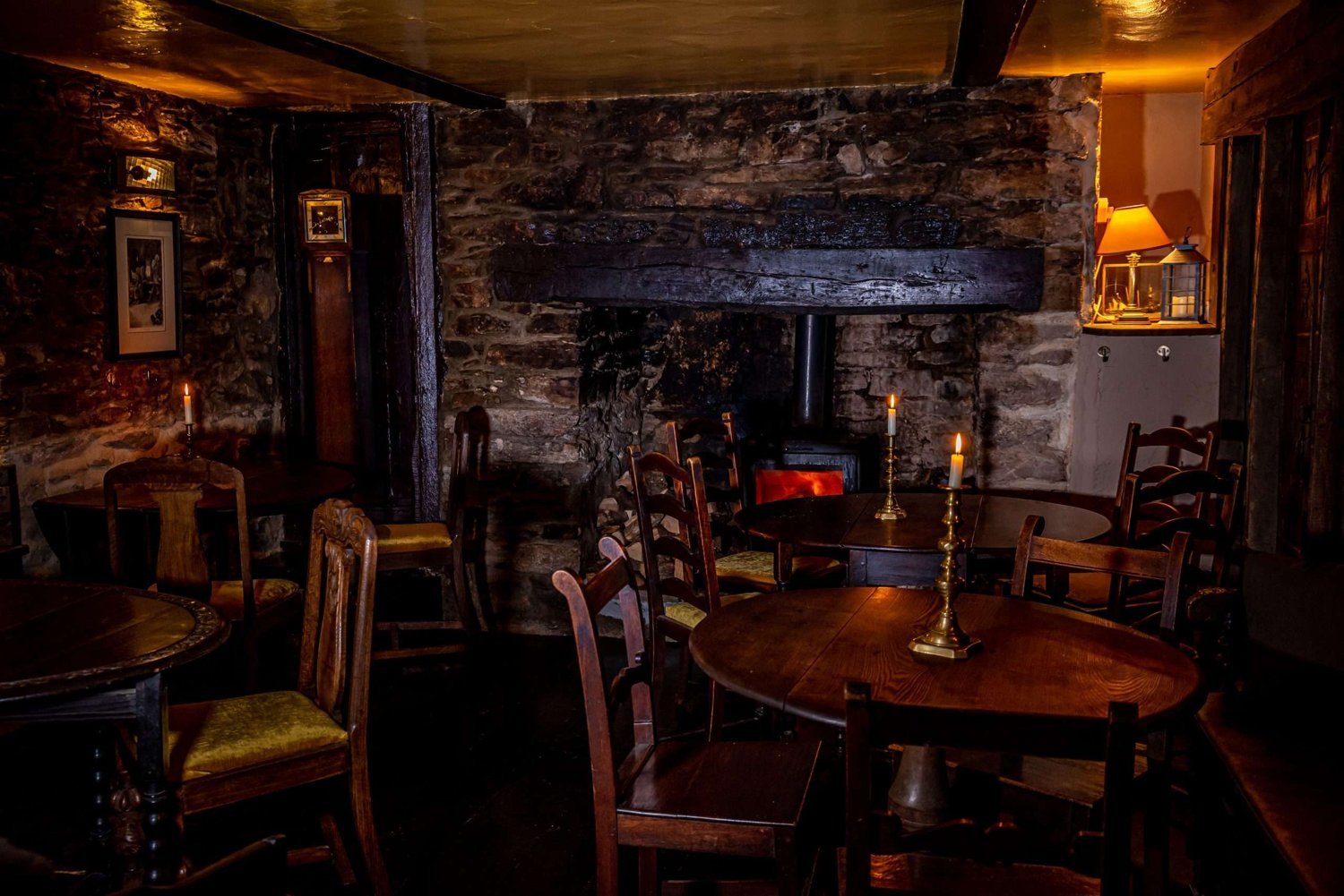 Fireplace and candlelit wooden tables inside the Old Exeter Inn