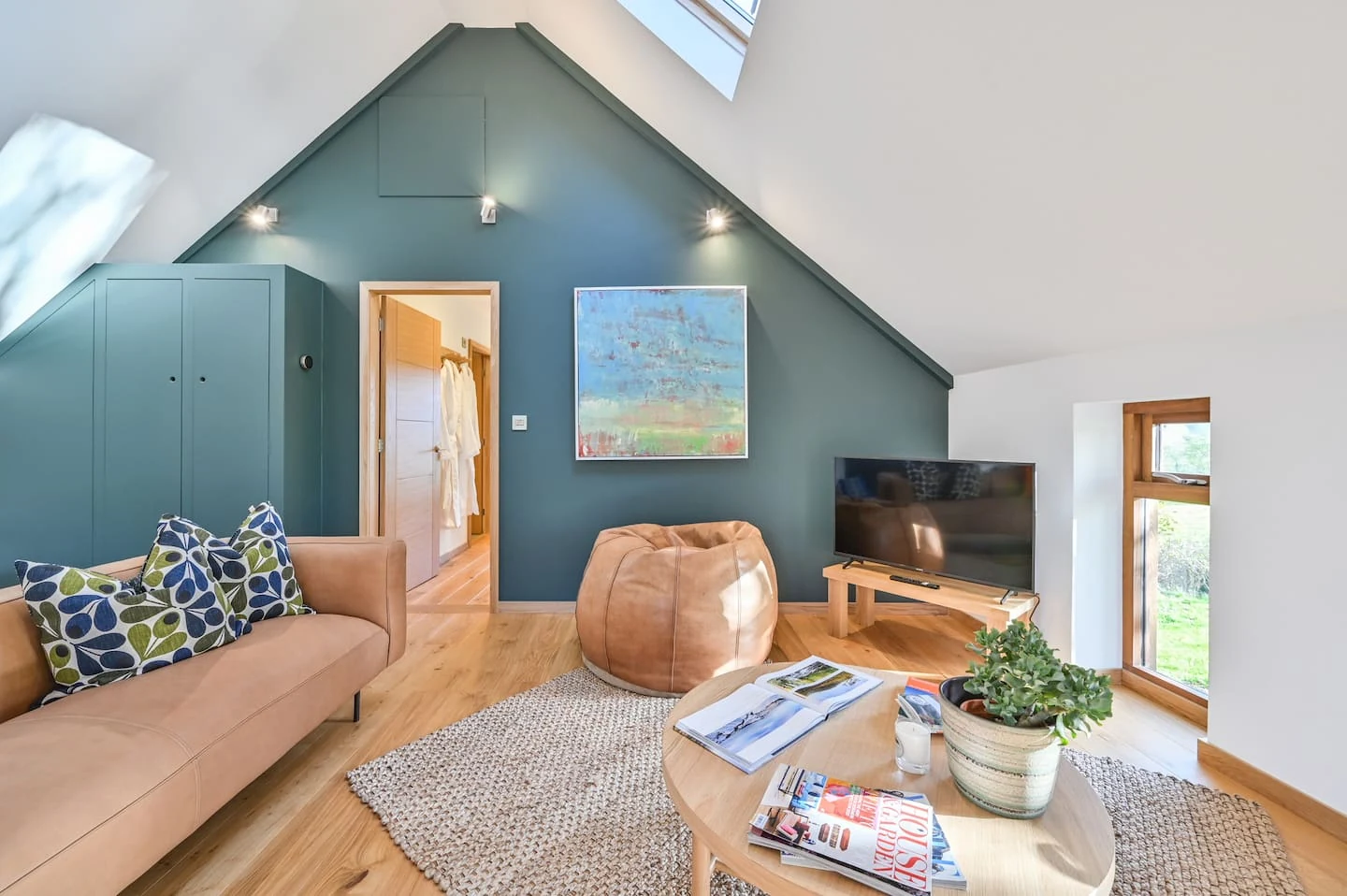 Sofa and artwork beneath the barn’s vaulted ceiling