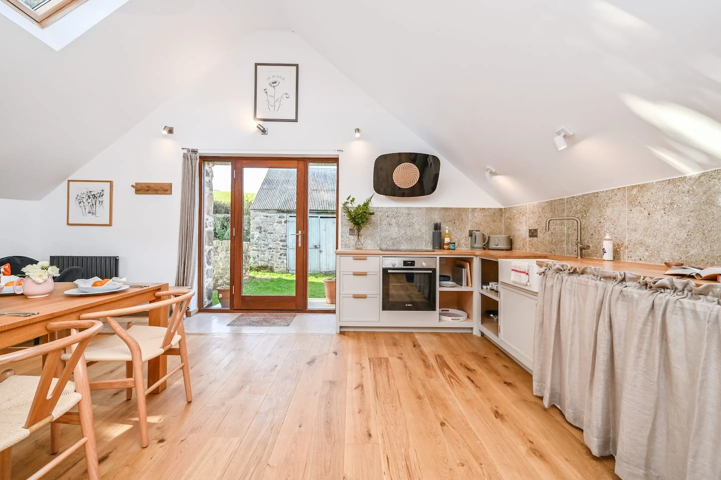 Oak kitchen and dining table beneath skylights