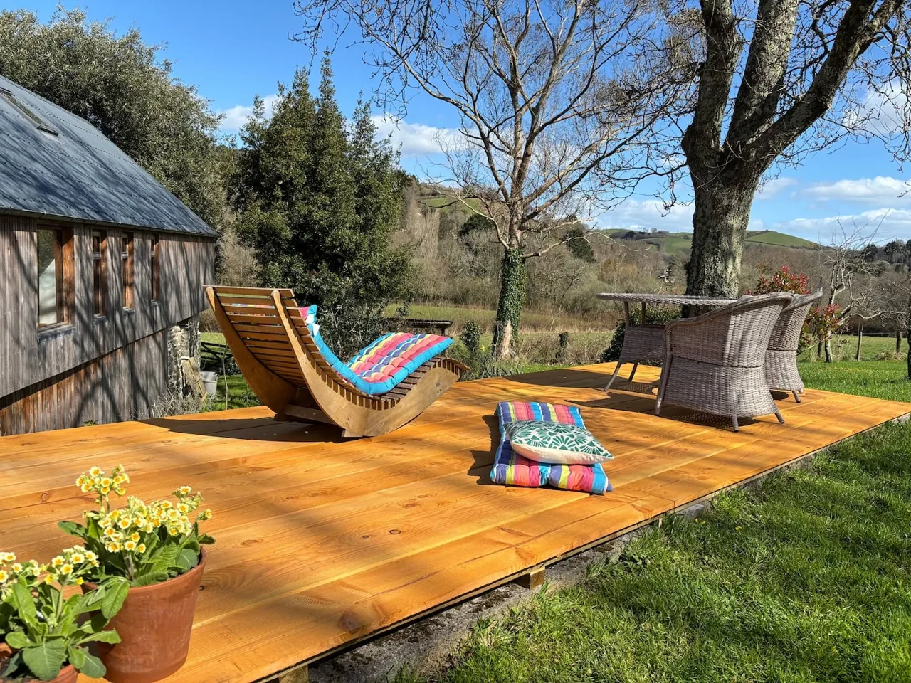 Outdoor chairs on the sunny wooden terrace