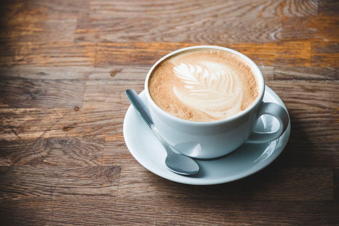 A cup of coffee on a wooden table at Otterton Mill