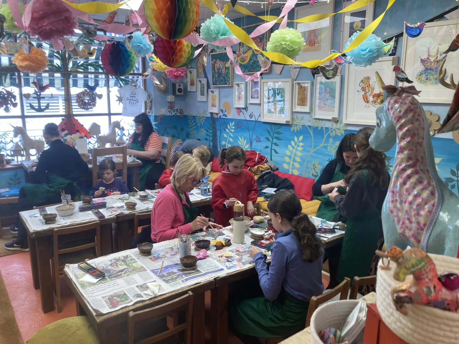 Adults and children decorating models at tables in Paper Bird Island