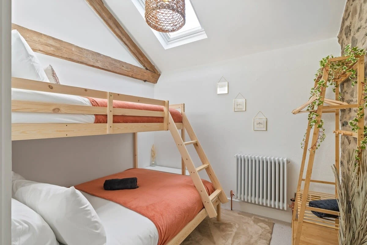 Wooden bunk bed beneath a sloping ceiling and skylight