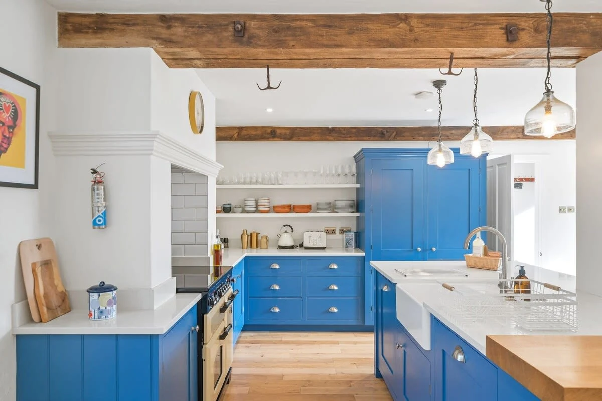 Blue kitchen cabinets and timber beams at Parkfield Barn