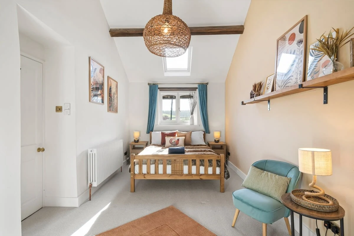 Bedroom with timber bed, blue curtains and a wicker pendant