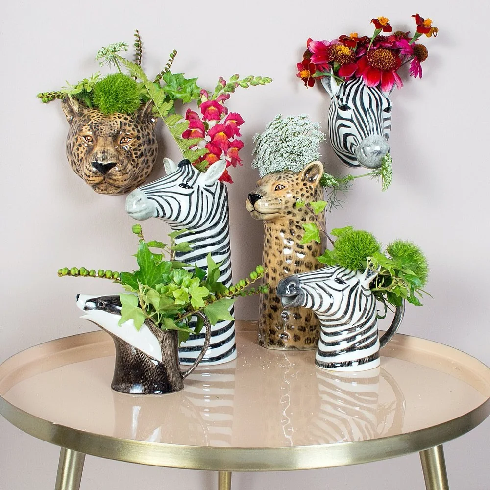 Animal-shaped ceramic jugs and vases filled with flowers
