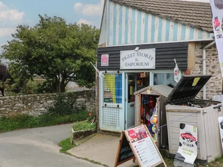 Piglet Stores and Emporium frontage with signs and an ice-cream freezer