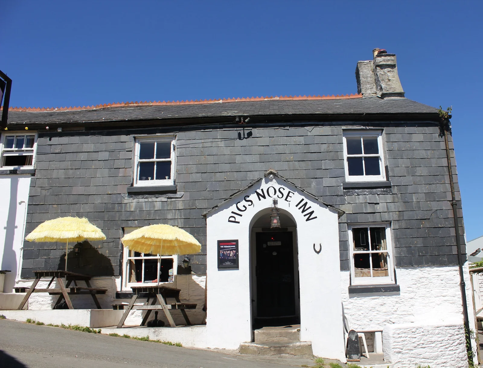 Whitewashed Pig’s Nose Inn frontage with outdoor tables