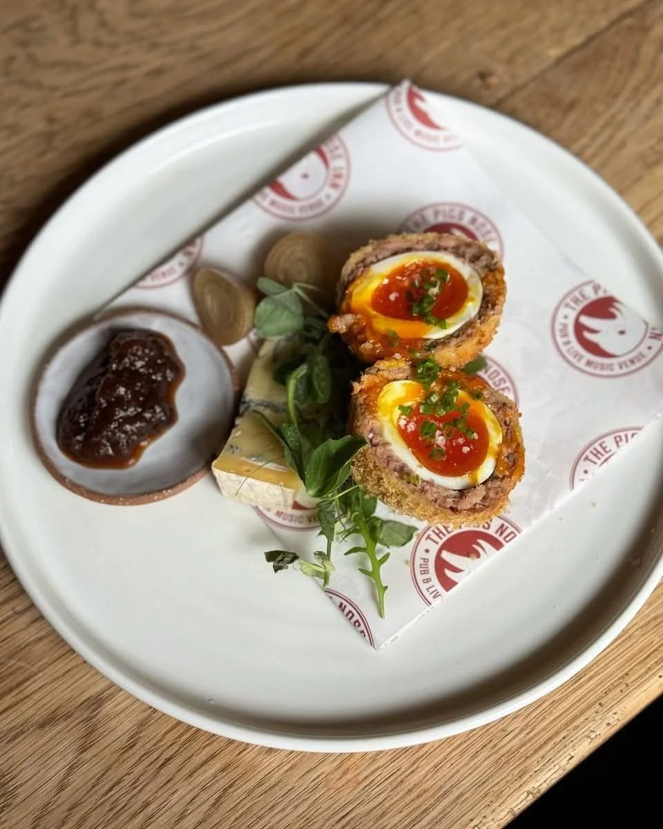 Scotch egg with salad and sauce on a patterned plate