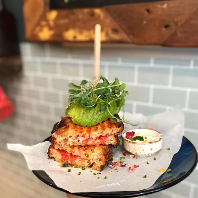 A tall breakfast sandwich with avocado at Port Espresso