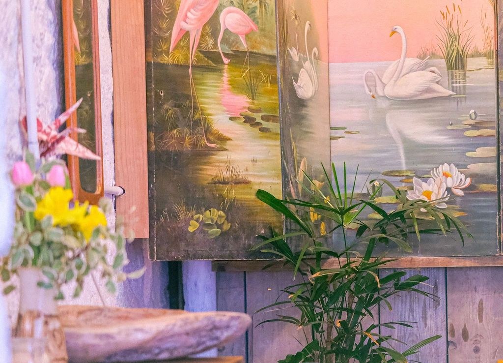 Pink flamingo mural, flowering plants and a table inside Rafikis in Ashburton.