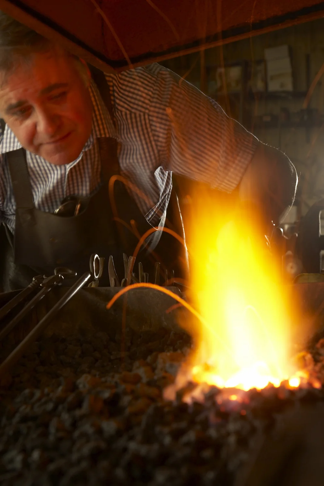 Blacksmith tending a bright forge fire