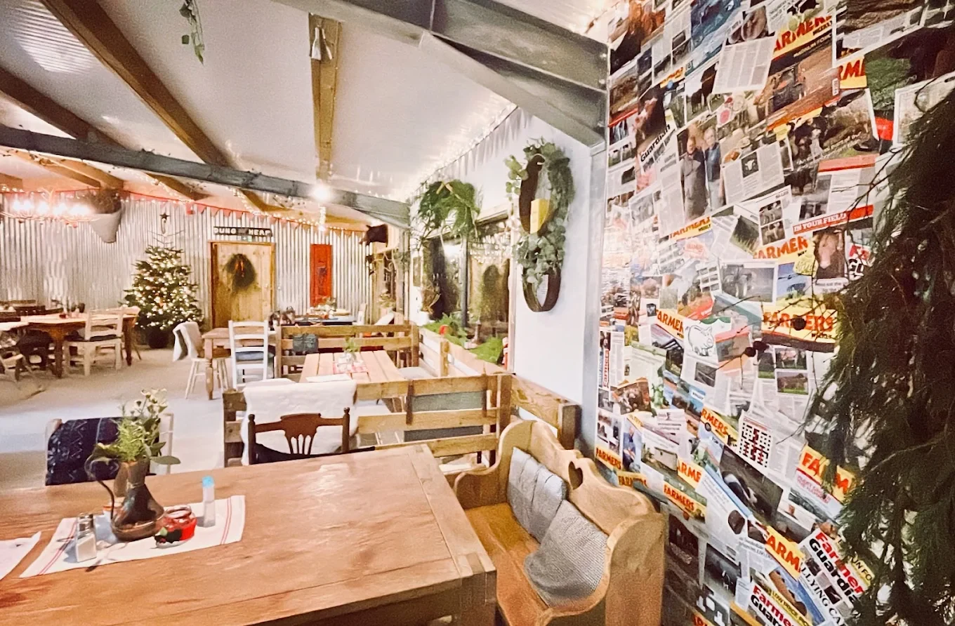 Wooden tables, mismatched chairs and a magazine-covered wall inside The Ring Feeder