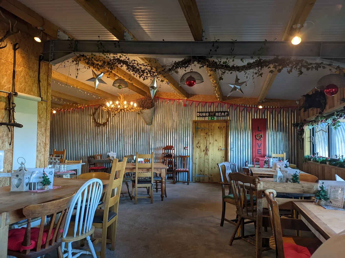 Rustic dining room with wooden beams, fairy lights and hanging stars at The Ring Feeder
