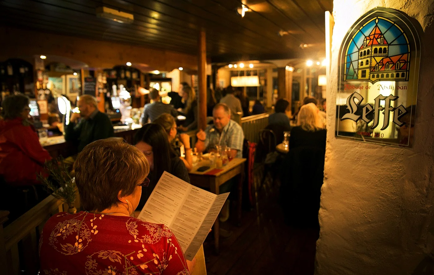 Diners and a reader with a menu inside Rumour