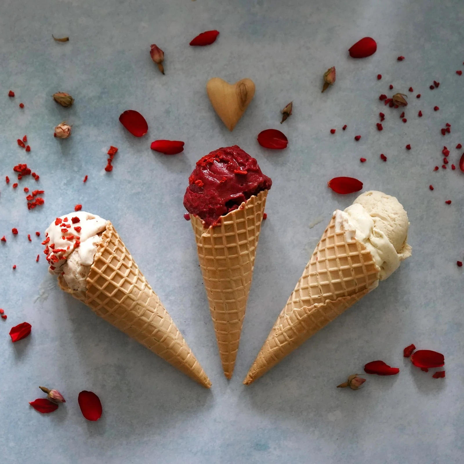 Three ice cream cones with scattered fruit and ingredients
