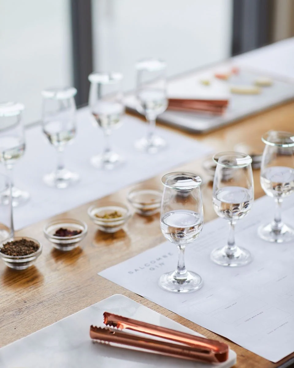 Tasting glasses and bowls of botanicals arranged on a table